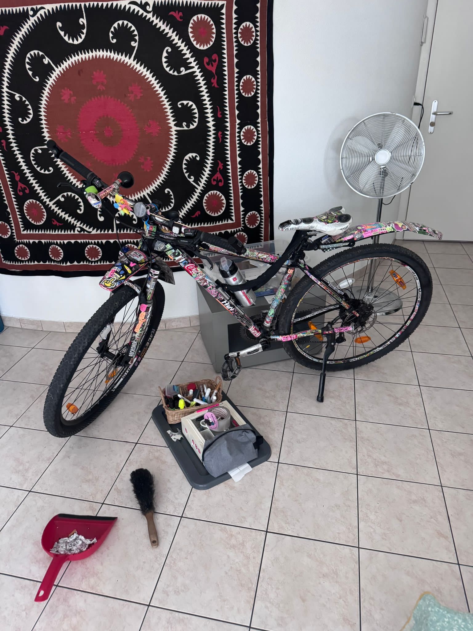 Vélo sur pied dans le salon, outils et pinceaux au sol