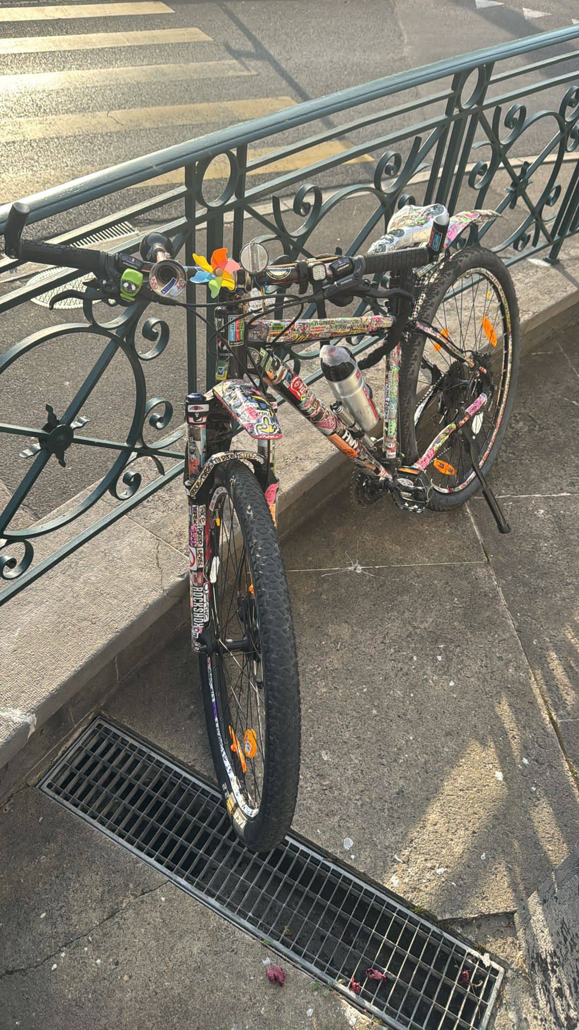 Vélo appuyé contre une rambarde en fer forgé, lumière du matin